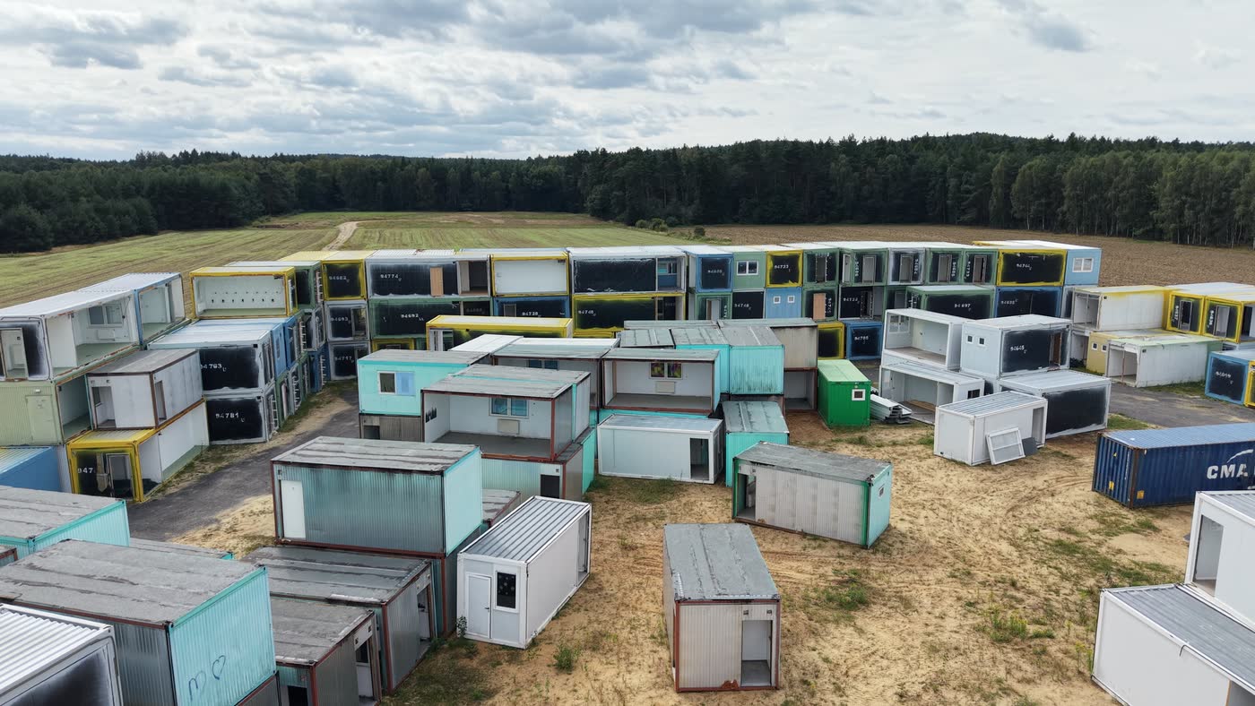 Rzędy używanych kontenerów biurowych i socjalnych widziane z niskiego przelotu drona